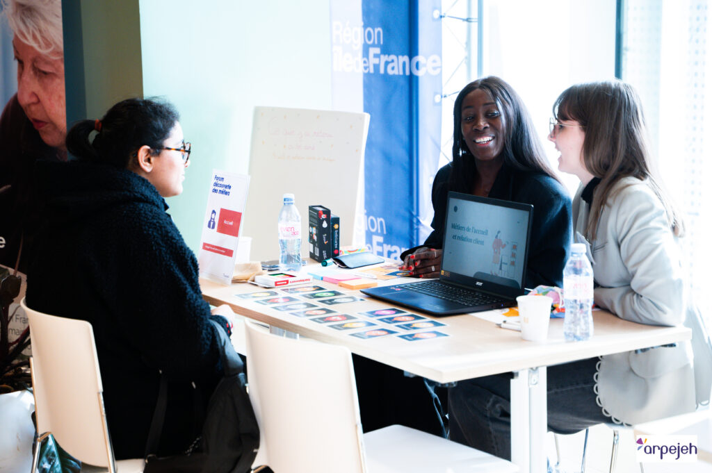 Des collaboratrices animant un stand au Forum Découverte des métiers d'arpejeh à Saint-Ouen, en plein échange avec une jeune.