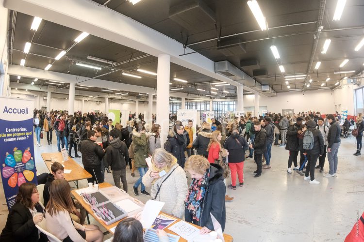 La salle est rempli de jeunes qui vont voir les exposants.