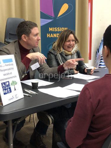 Deux collaborateurs présentent la mission handicap à des jeunes.